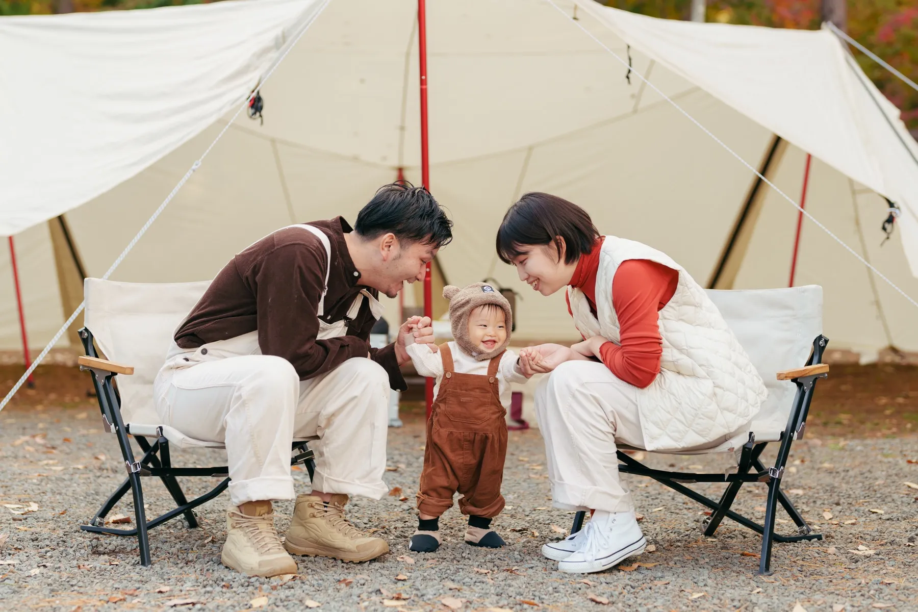 キャンプ場で子どもを囲む家族写真