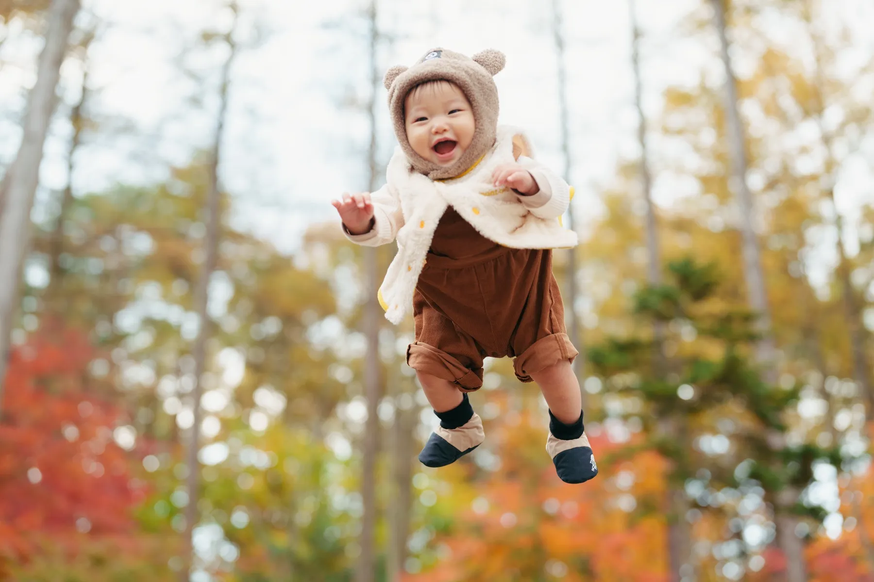 子どもが笑顔で走ってくる家族写真