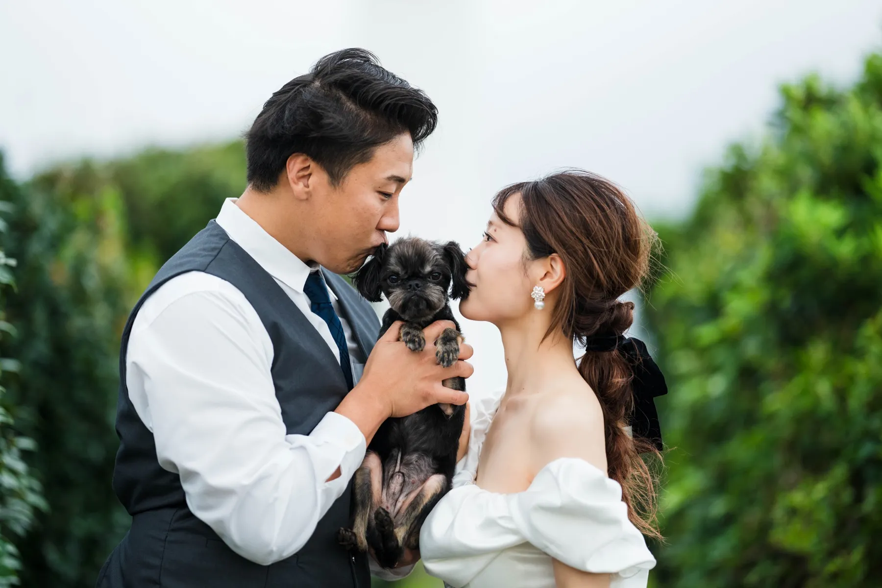 愛犬と一緒に寄り添うウェディング前撮りの二人