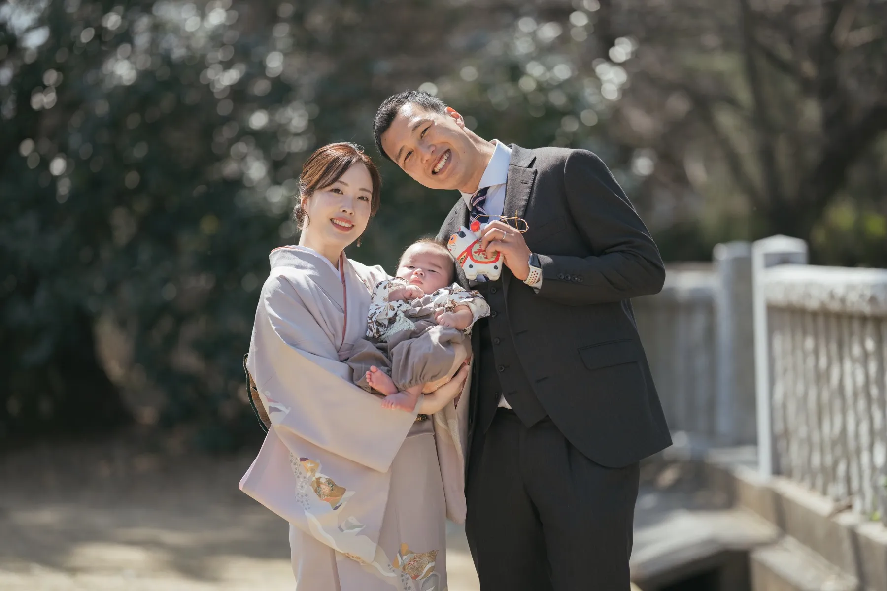 自然光の中で赤ちゃんを見つめるお宮参りの写真