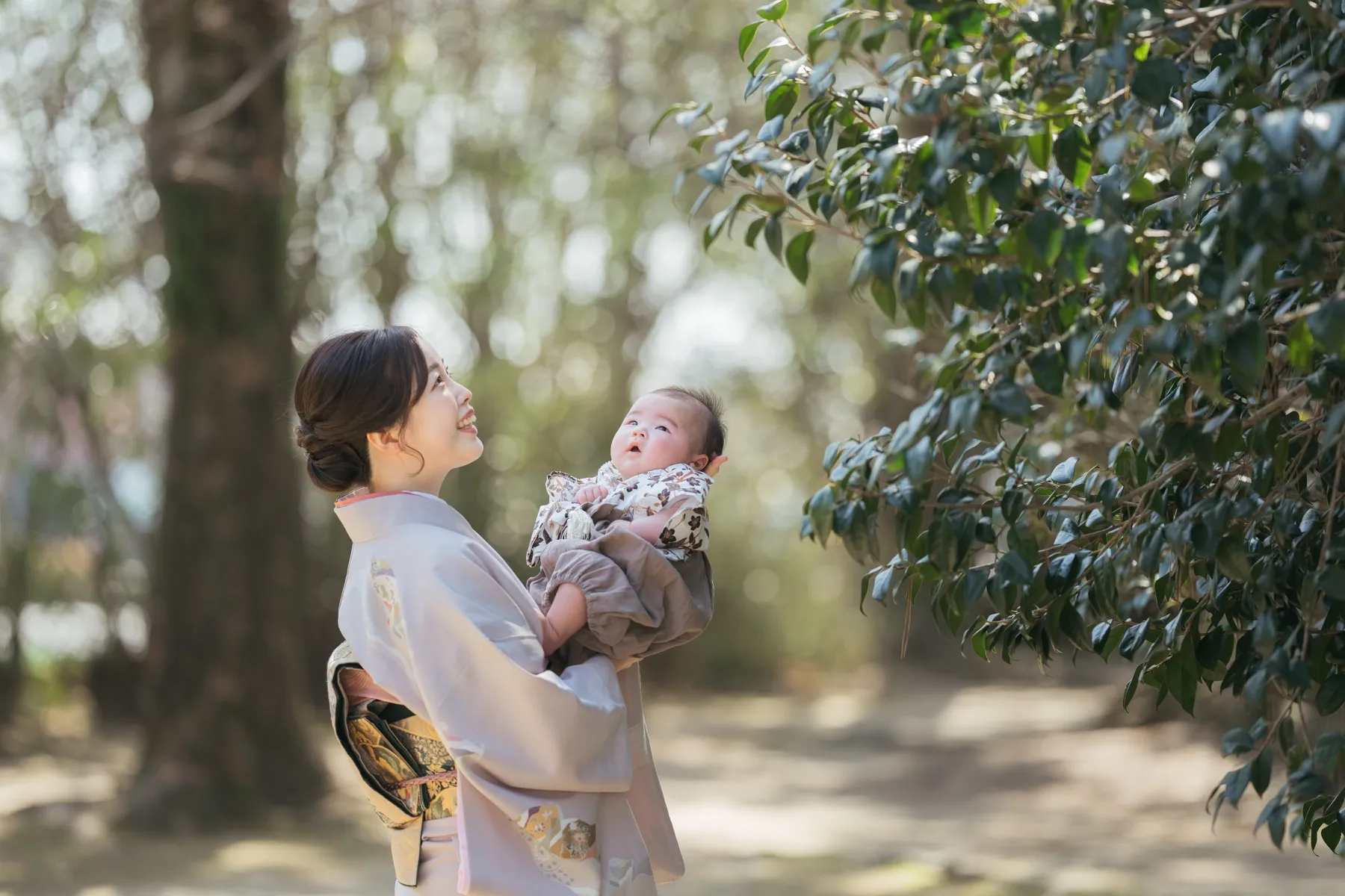 神社で並んで座るお宮参りの家族写真
