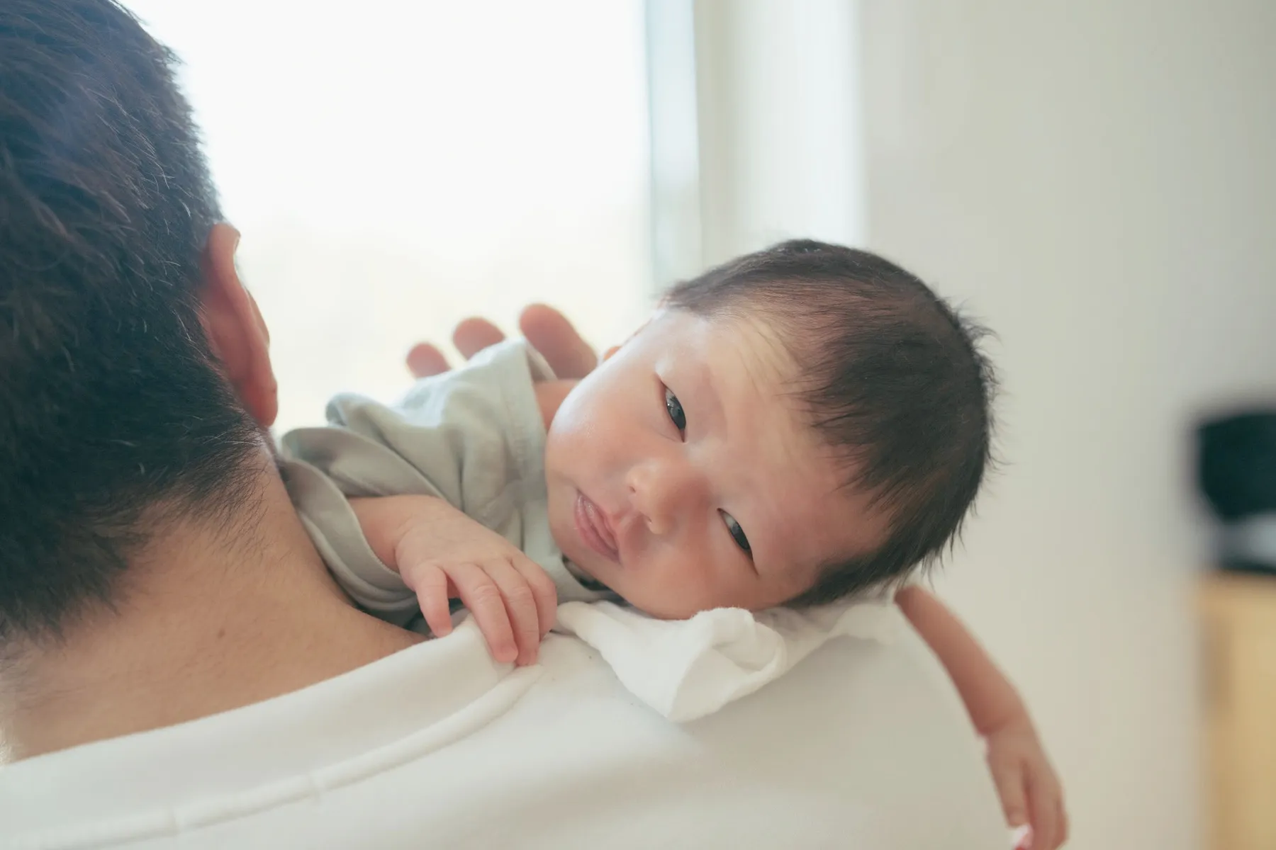 赤ちゃんを肩に抱くニューボーンフォト
